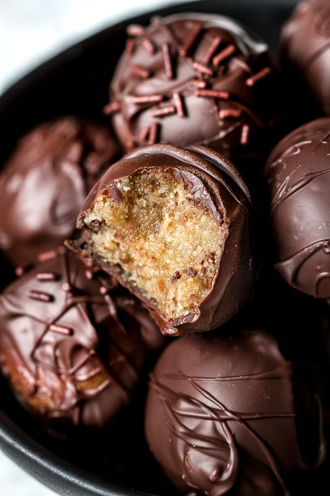 Melt-in-your-mouth 3 ingredient cookie dough truffles that taste and feel just like a decadent dessert but are made with NO grains, oil, eggs, or refined sugars. They’re gluten-free, vegan, and a healthy and delicious way to satisfy those chocolate cravings! | runningwithspoons.com