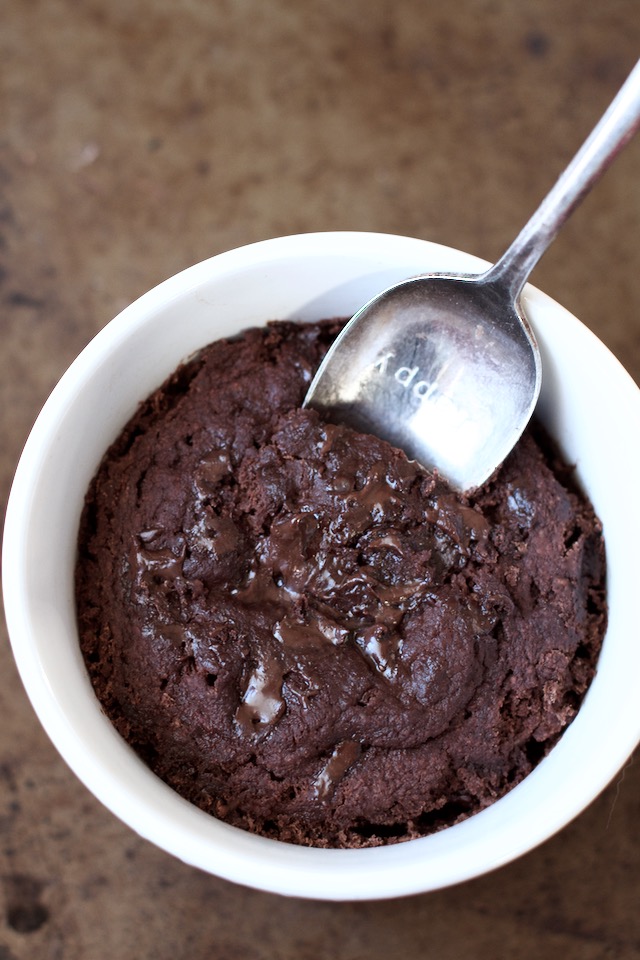A healthy two minute brownie in a small bowl with a spoon.