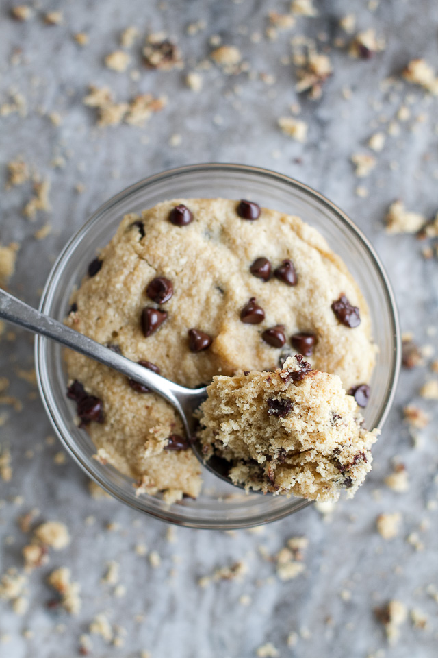 A chocolate chip cookie dough mug cake with a spoonful taken out of it.