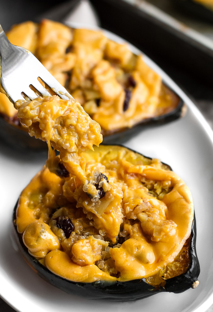 This cheezy apple cranberry quinoa stuffed squash is packed with sweet & savoury flavours and topped with an ooey, gooey, dairy-free cheese. It's healthy plant-based comfort food at its finest! | runningwithspoons.com