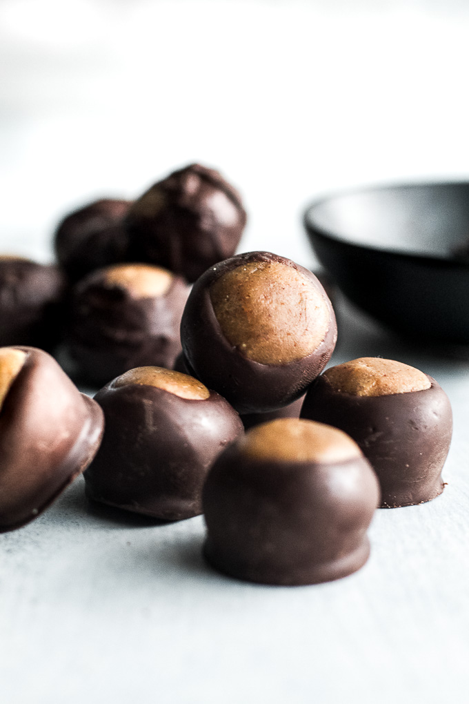 You won't miss the butter or sugar in these healthy buckeyes! They're made with wholesome ingredients like coconut flour and maple syrup, and make a delicious alternative to a traditional favourite! {gluten-free, vegan, paleo} | runningwithspoons.com