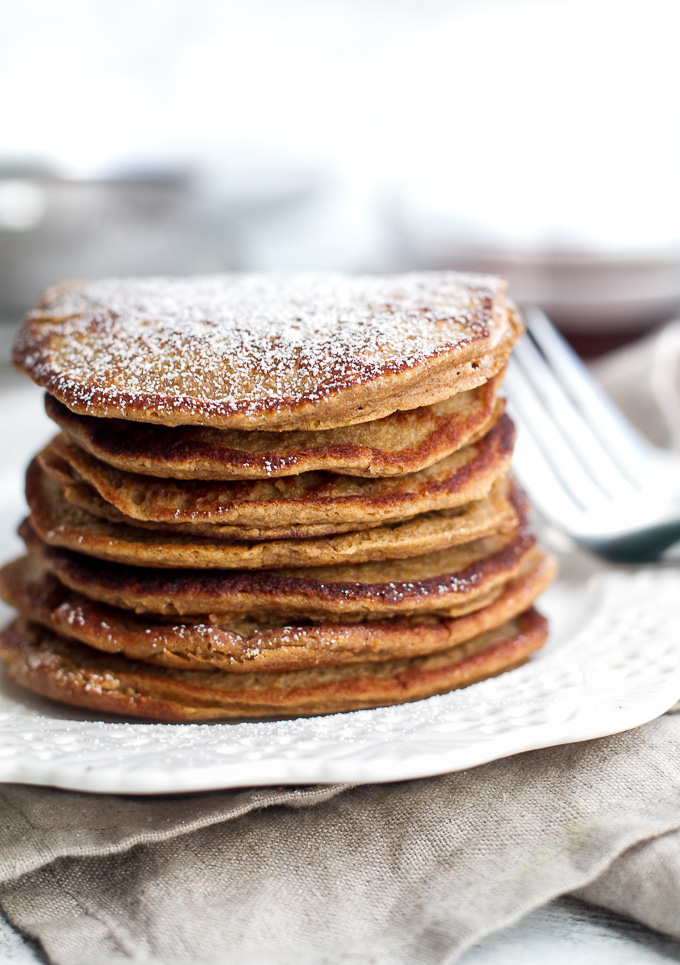 These light and fluffy Gingerbread Greek Yogurt Pancakes are sure to keep you satisfied all morning with over 20g of whole food protein! They’re gluten-free thanks to the oats, whipped up in the blender in under 5 minutes, and LOADED with sweetness and spice | runningwithspoons.com