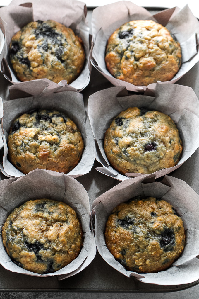 These blueberry banana oatmeal muffins are made with NO butter or oil, but so soft and tender that you'd never be able to tell! Super easy to whip up in only ONE BOWL, they make a deliciously healthy breakfast or snack. | runningwithspoons.com