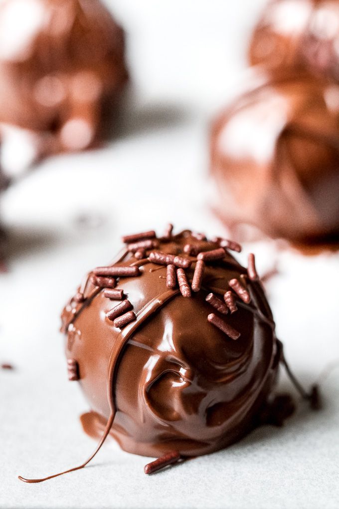 Melt-in-your-mouth 3 ingredient cookie dough truffles that taste and feel just like a decadent dessert but are made with NO grains, oil, eggs, or refined sugars. They’re gluten-free, vegan, and a healthy and delicious way to satisfy those chocolate cravings! | runningwithspoons.com
