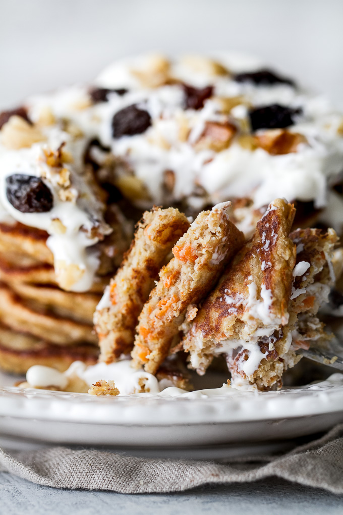 These light and fluffy Carrot Cake Greek Yogurt Pancakes are sure to keep you satisfied all morning with over 20g of whole food protein! They’re gluten-free thanks to the oats and whipped up in the blender in under 5 minutes! | runningwithspoons.com