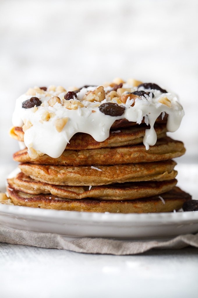 These light and fluffy Carrot Cake Greek Yogurt Pancakes are sure to keep you satisfied all morning with over 20g of whole food protein! They’re gluten-free thanks to the oats and whipped up in the blender in under 5 minutes! | runningwithspoons.com