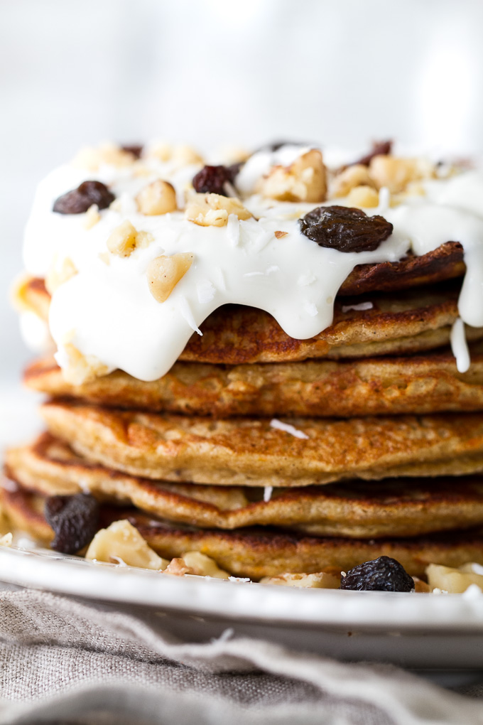 These light and fluffy Carrot Cake Greek Yogurt Pancakes are sure to keep you satisfied all morning with over 20g of whole food protein! They’re gluten-free thanks to the oats and whipped up in the blender in under 5 minutes! | runningwithspoons.com