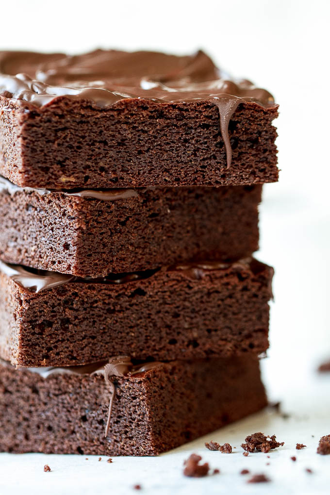 A stack of flourless sweet potato brownies with chocolate drizzle.