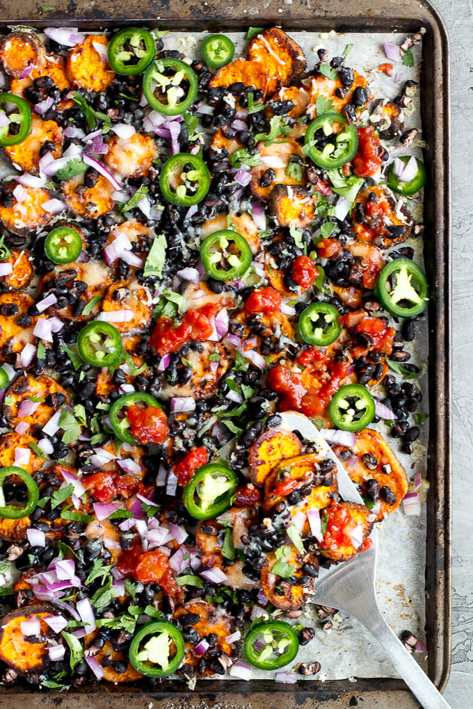 Loaded Sweet Potato Nachos - seasoned baked rounds topped with black beans, jalapeños, onions, cheese, salsa, and guacamole for an easy vegetarian, Mexican-inspired meal that's way healthier than traditional nachos | runningwithspoons.com