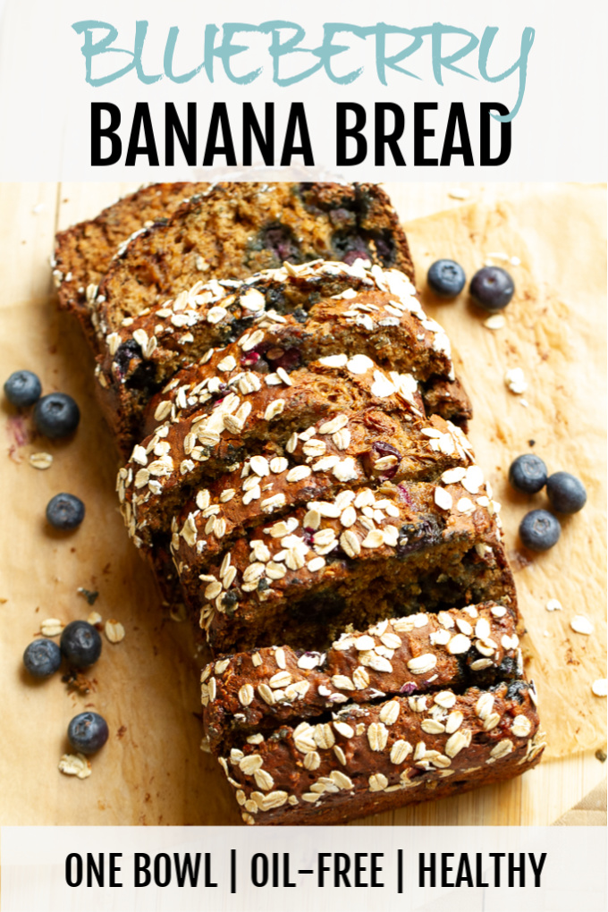 A loaf of blueberry banana bread on a cutting board.