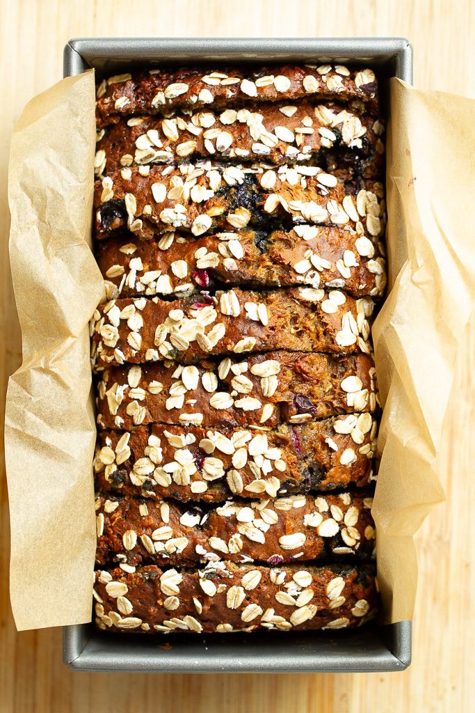 A loaf of blueberry banana bread in a bread pan.