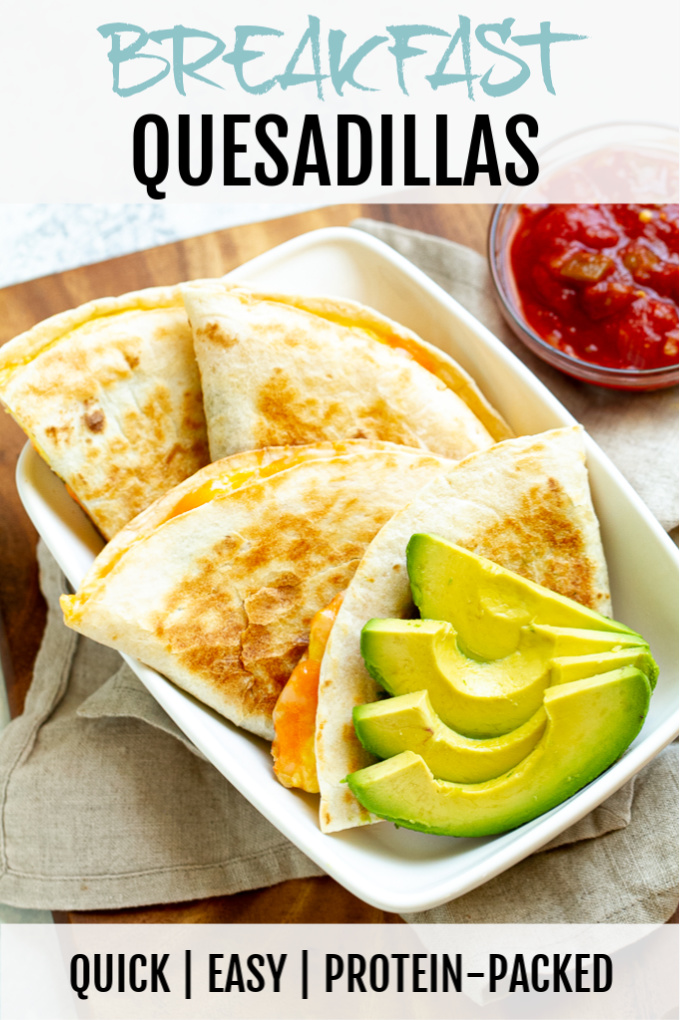 Breakfast quesadillas on a plate with some avocado and salsa.