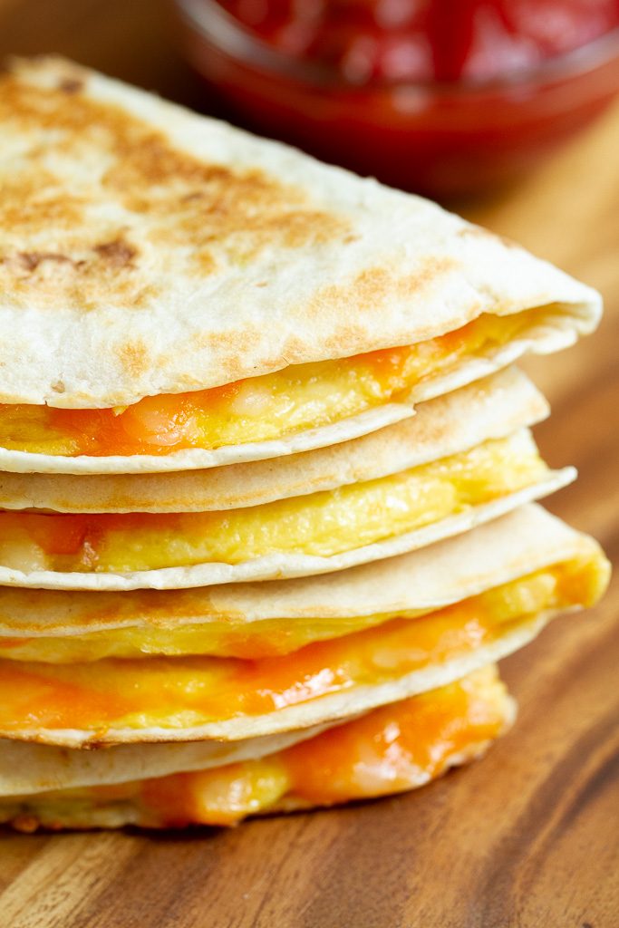 Sliced breakfast quesadilla halves stacked on top of each other.
