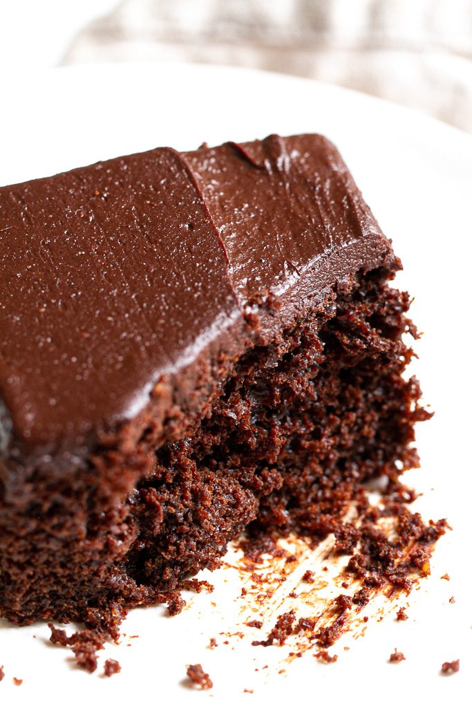 A slice of easy chocolate sheet cake with a bite taken out of it.