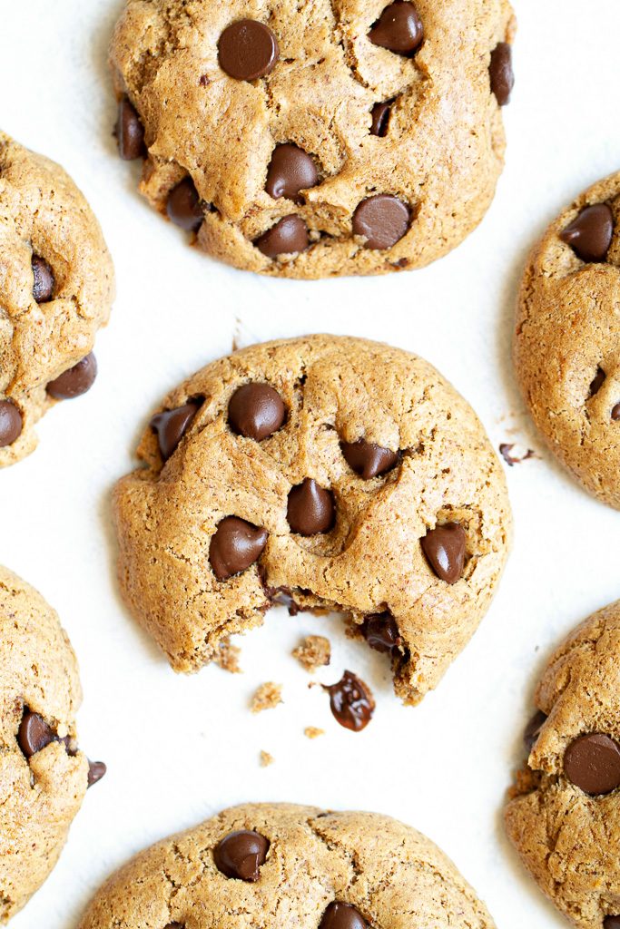 A flourless chocolate chip cookie with a bite taken out of it.